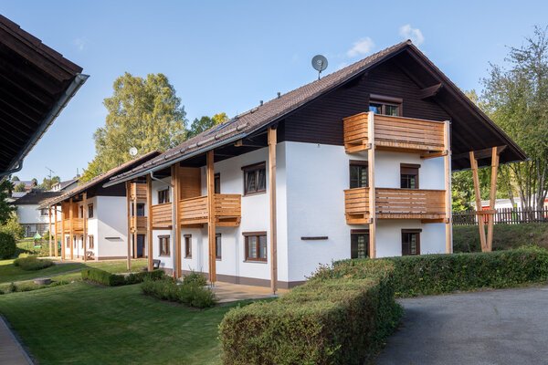 Ferienanlage Bäckerwiese in Neuschönau mit heller Fassade, Holzbalkonen und Garten