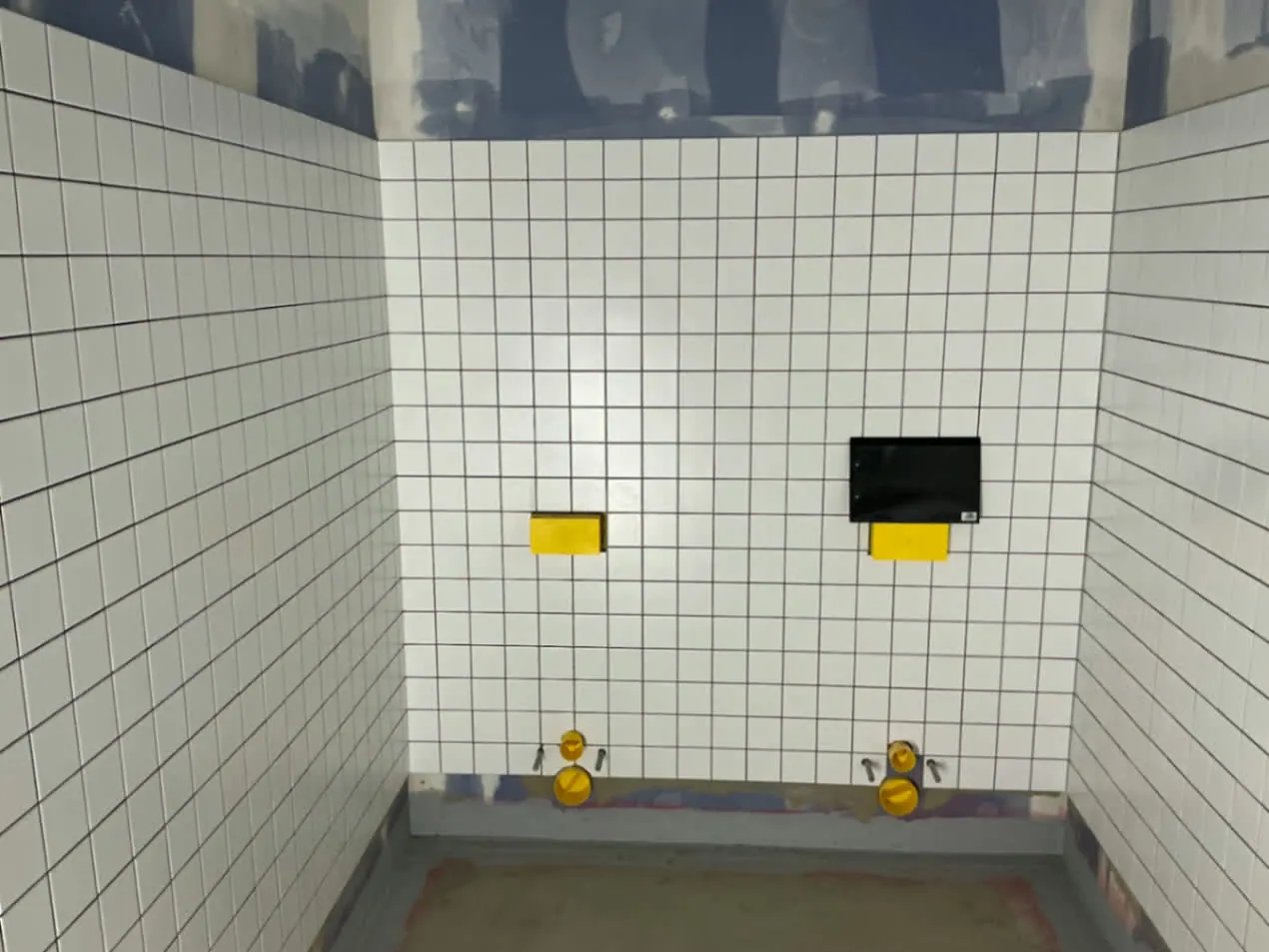 Gefliester Sanitärraum im Neubau der Grundschule Altdorf mit weißen Wandfliesen